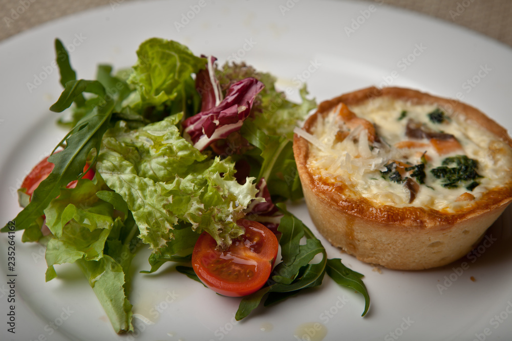 julienne in tartlet with salad and tomatoes on a white plate