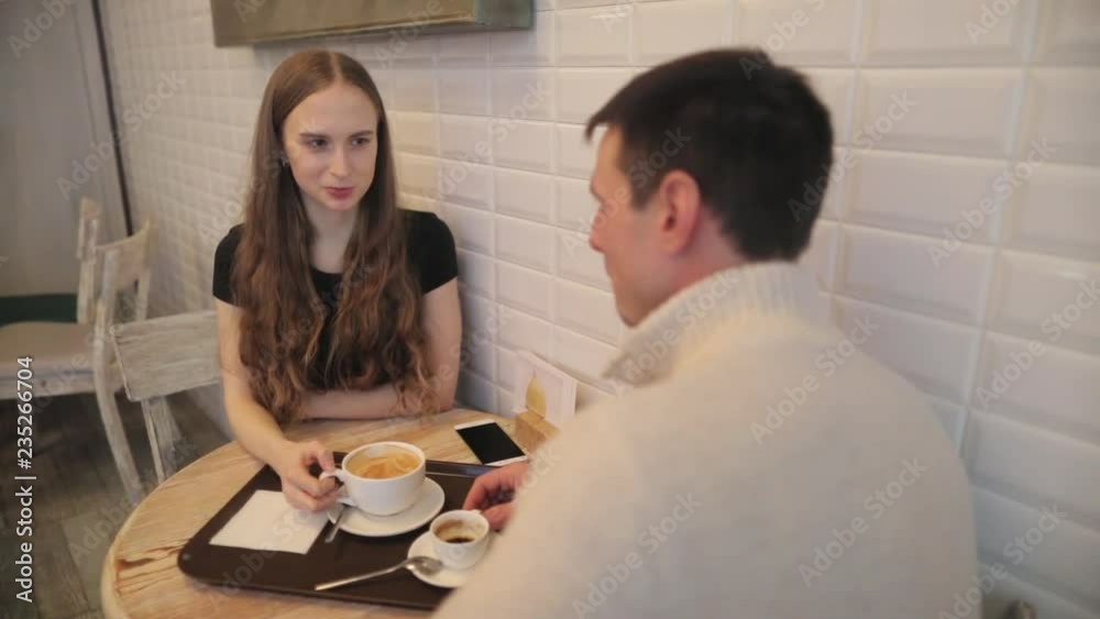 Young people in a cafe are discussing the trip on weekends. Coffee is served with espresso and lat. Young people in a cafe are discussing the trip on weekends. Coffee is served with espresso and lat.