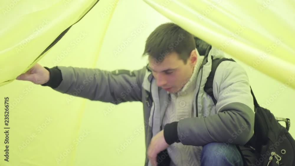 A man checks the reliability of the tents for hiking. A man checks the reliability of the tents for hiking.