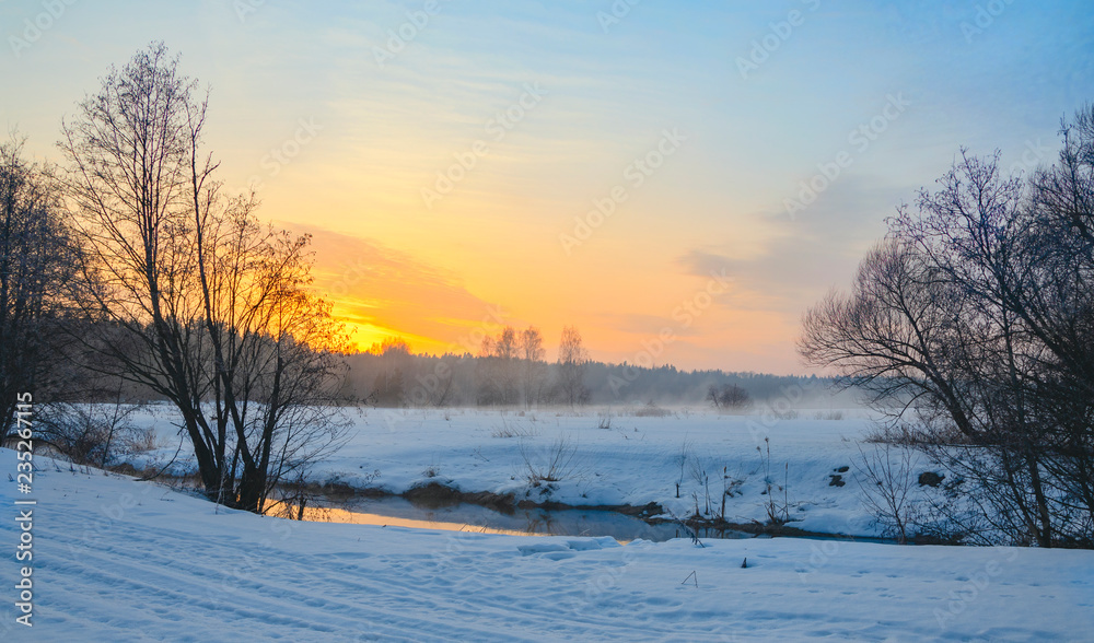 Frosty foggy winter landscape with small forest river and rising sun. Frosty foggy winter landscape with small forest river and rising sun.