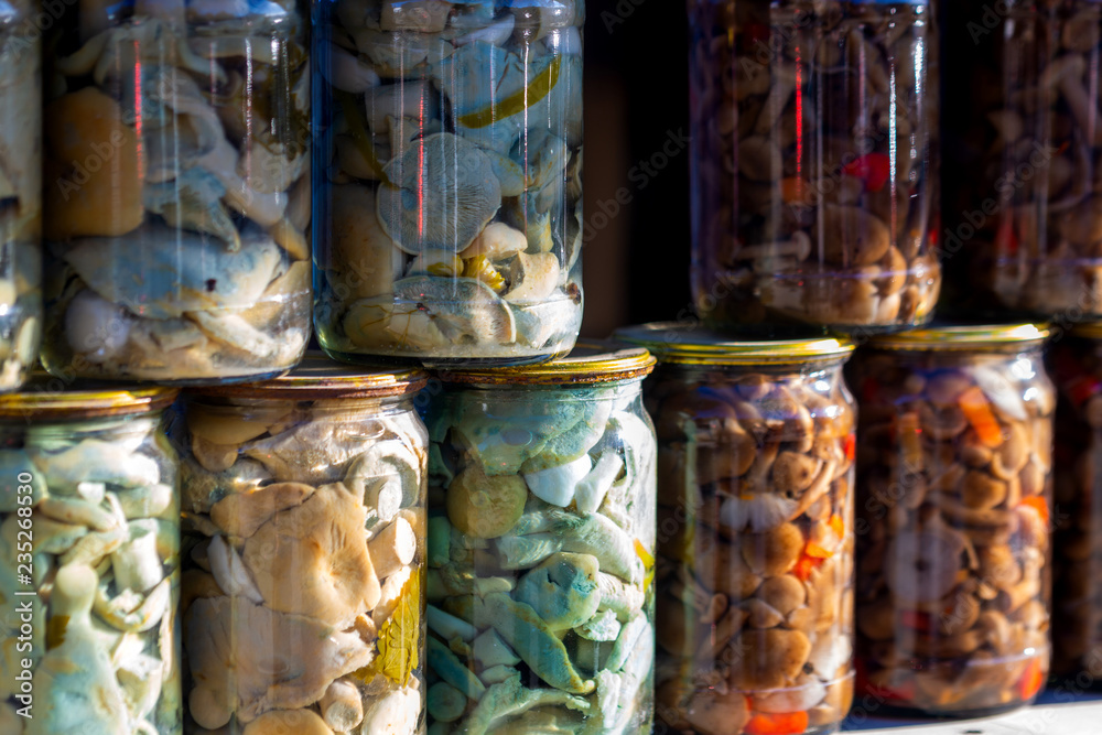 Fototapeta premium Pickled honey mushrooms in jars at village marketplace