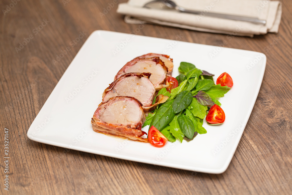 Roasted Pork Tenderloin Wrapped in bacon with lettuce and tomatoes Roasted Pork Tenderloin Wrapped in bacon with lettuce and tomatoes