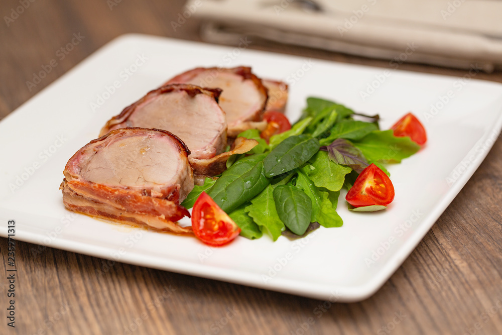 Roasted Pork Tenderloin Wrapped in bacon with lettuce and tomatoes Roasted Pork Tenderloin Wrapped in bacon with lettuce and tomatoes