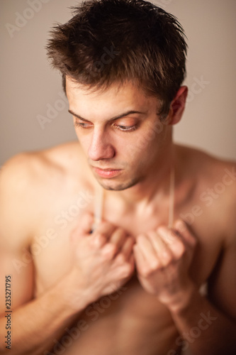 Attractive swimmer. Studio shot of a young shirtless athlete on a gray background.