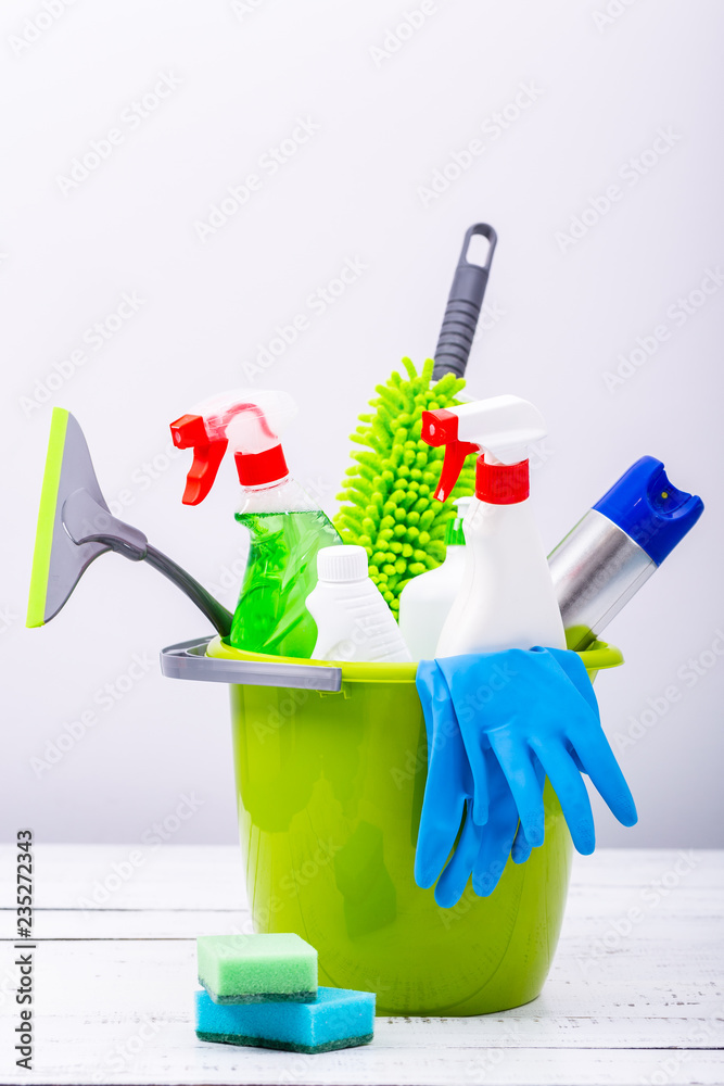 Spring cleaning concept. Cleaning supplies on wood background.