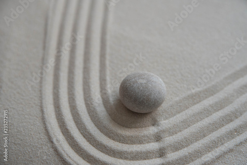 Gray zen stones on the sand with wave drawings. Concept of harmony, balance and meditation, spa, massage, relax