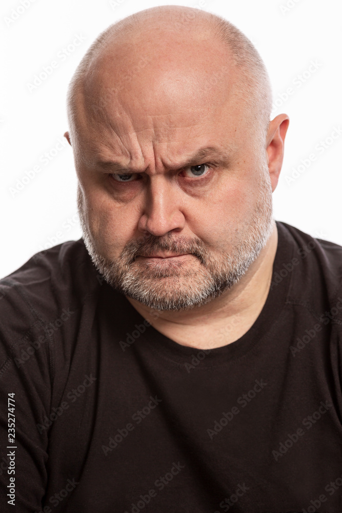 Bald man with angry facial expression, close-up Bald man with angry facial expression, close-up