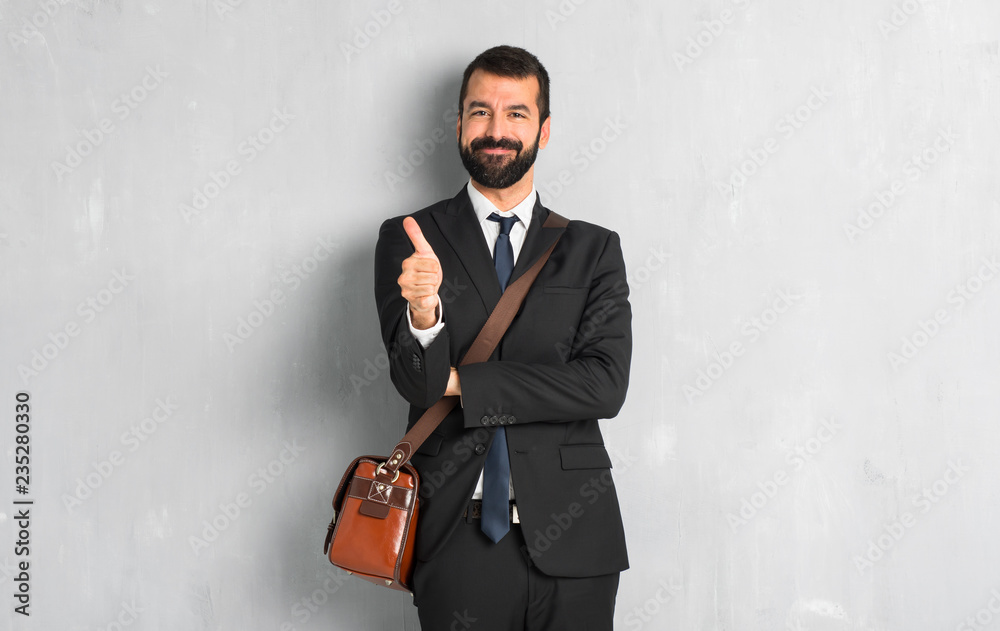 Businessman with beard giving a thumbs up gesture because something good has happened Businessman with beard giving a thumbs up gesture because something good has happened