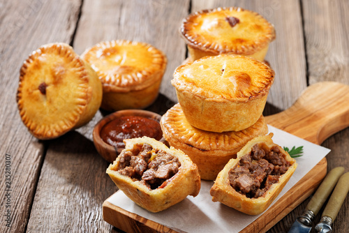 Tableau sur toile Traditional Australian Mini meat pies from shortbread dough on a wooden board over wooden background