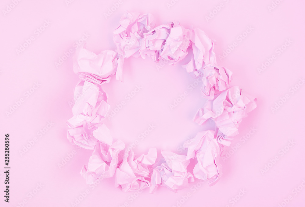 Pastel pink abstract background image made from crumpled paper arranged into a circle with copy space.