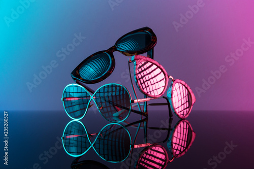 Sunglasses stacked in a pile with vivid color, hot pink and blue.