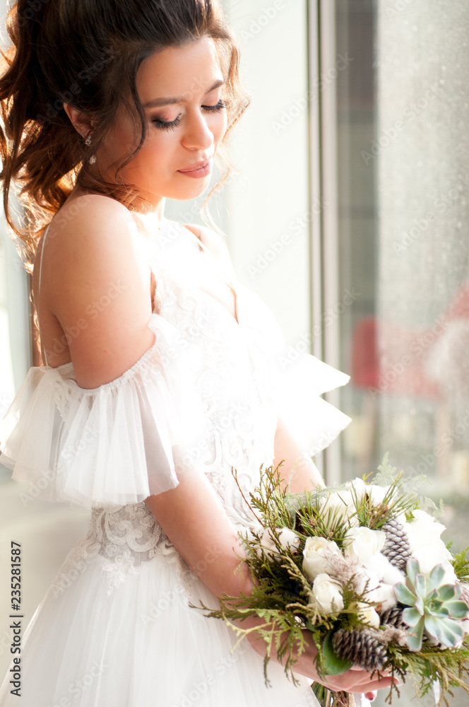Bride in a white wedding dress with a Christmas bouquet of flowers Bride in a white wedding dress with a Christmas bouquet of flowers