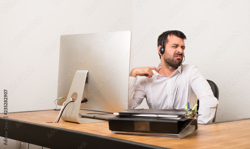 Telemarketer man in a office with tired and sick expression Telemarketer man in a office with tired and sick expression