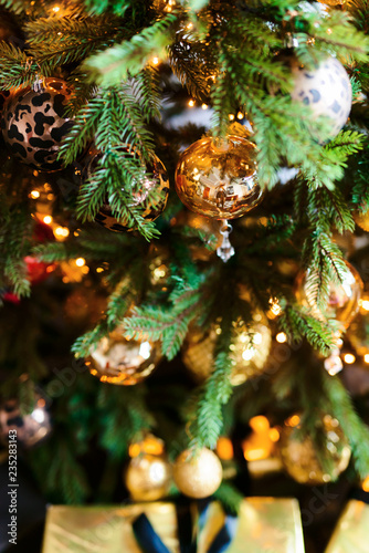 Merry Christmas and Happy New year Holidays! Decorating the Christmas tree indoors. Macro or close picture of xmas tree and gifts under it. Gift box background for 2019 new year gift card