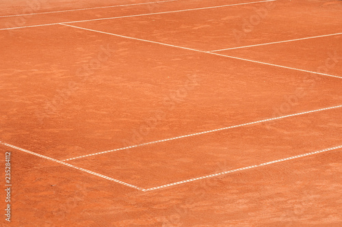Part of empty used red clay tennis court playground surface with white lines closeup © varbenov