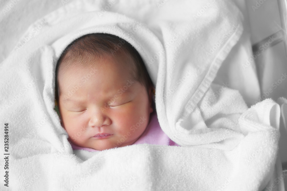 asian newborn baby or head and face infant sleep on white towel with diaper in children hospital with space asian newborn baby or head and face infant sleep on white towel with diaper in children hospital with space