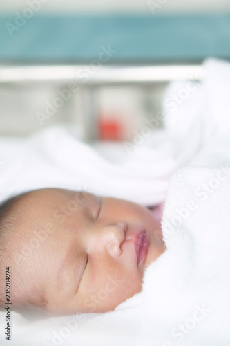 asian newborn baby or head and face infant sleep on white towel with diaper and have lymph node on nose in children hospital with space on vertical