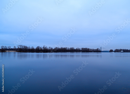 View across the river to the dark forest away in cold weather. © YAROSLOVEPHOTOVIDEO