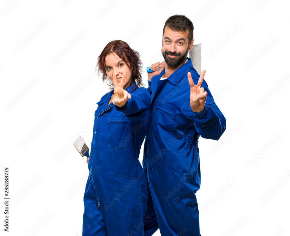 Painters smiling and showing victory sign on isolated white background Painters smiling and showing victory sign on isolated white background