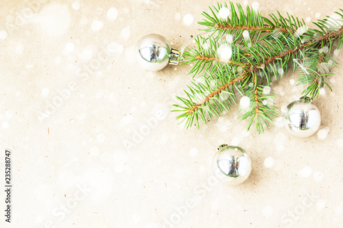 Fir tree branches decorated with silver christmas balls as border on a snow rustic holiday background frame