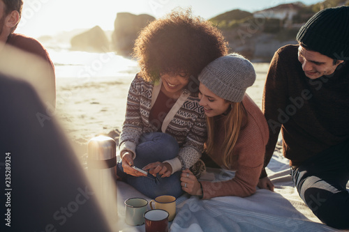 Group of friends at the beach with a smartphone