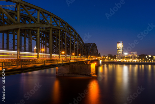 Blick auf die Hohenzollernbrücke, den Köln Triangle, das Hyatt Hotel und den Rhein bei Nacht in Köln.