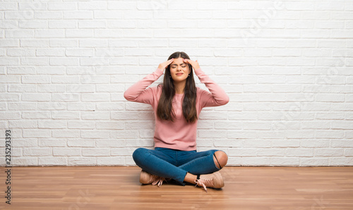 Teenager girl sitting on the floor in a room unhappy and frustrated with something
