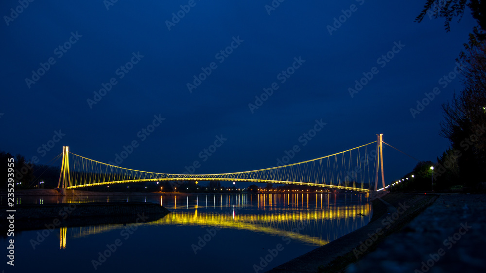 Side view of a colorful modern pedestrian bridge. Night in Osijek, Croatia.