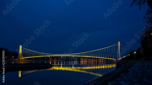 Obraz na płótnie Side view of a colorful modern pedestrian bridge. Night in Osijek, Croatia. w salonie