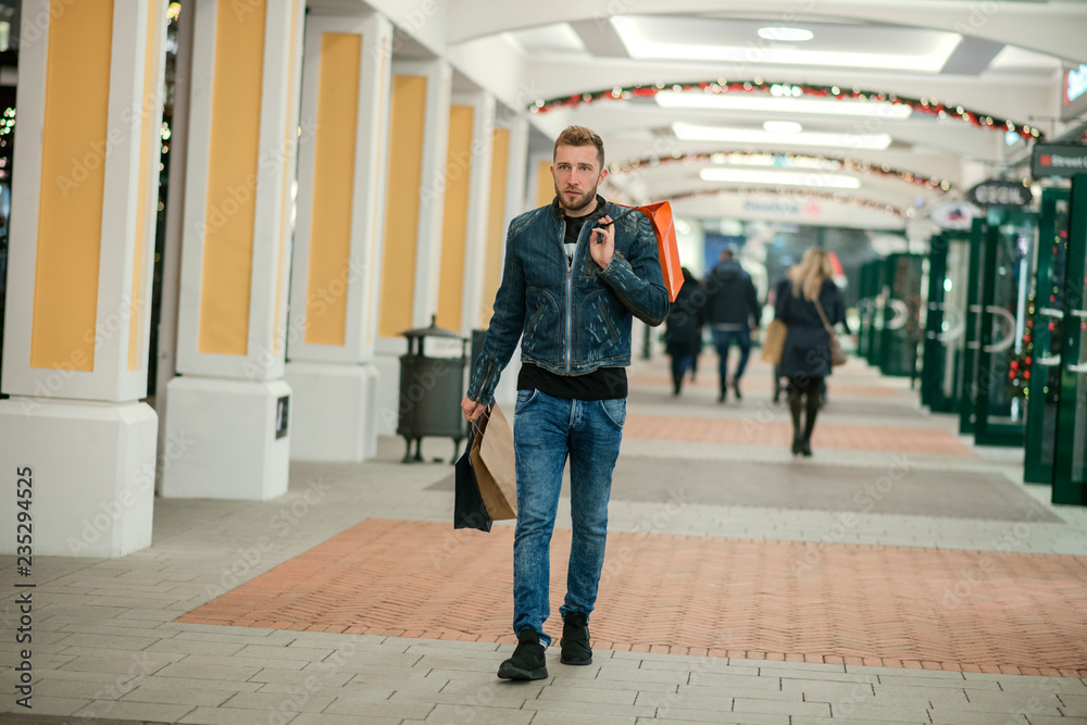 Fototapeta premium Handsome young man doing his holiday shopping