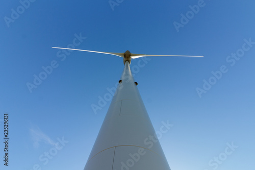 Underside of wind turbine against blue sky in portugal