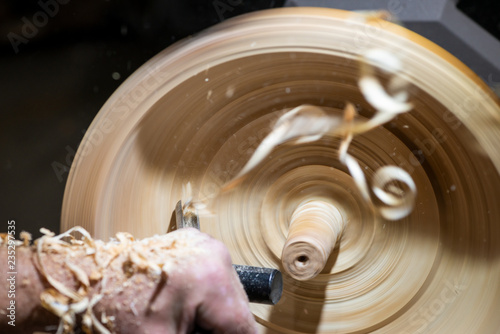 wood shavings in motion while turnery of a wooden bowl with chisel