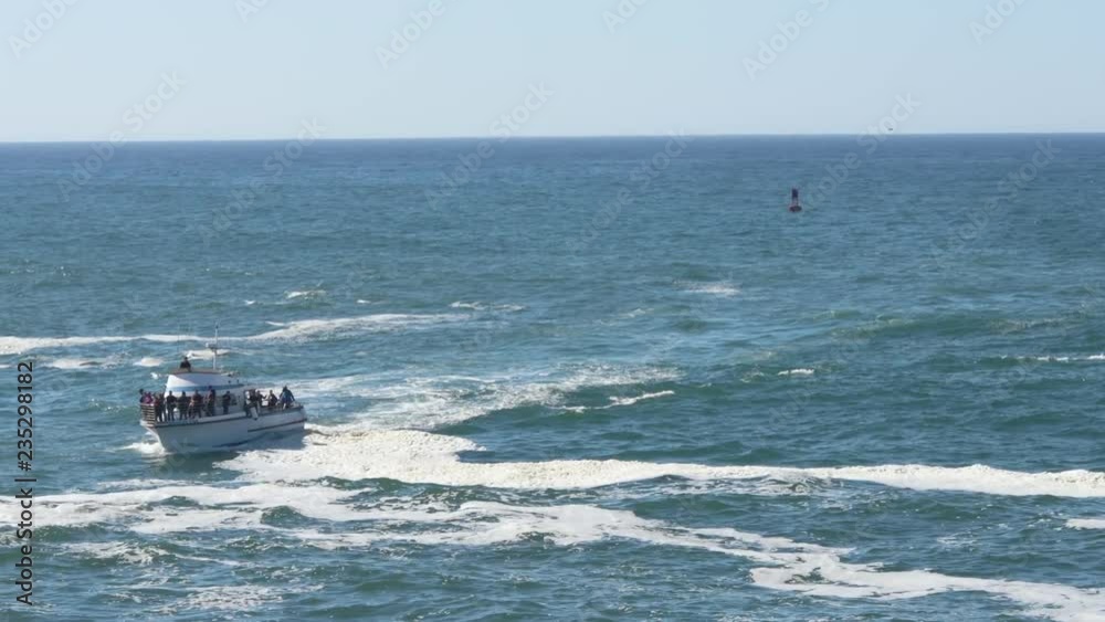 A whale watching boat coming in near Depoe bay, crowded with tourists, a buoy in the background. A whale watching boat coming in near Depoe bay, crowded with tourists, a buoy in the background.
