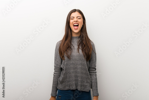 Teenager girl on isolated white backgorund shouting to the front with mouth wide open © luismolinero