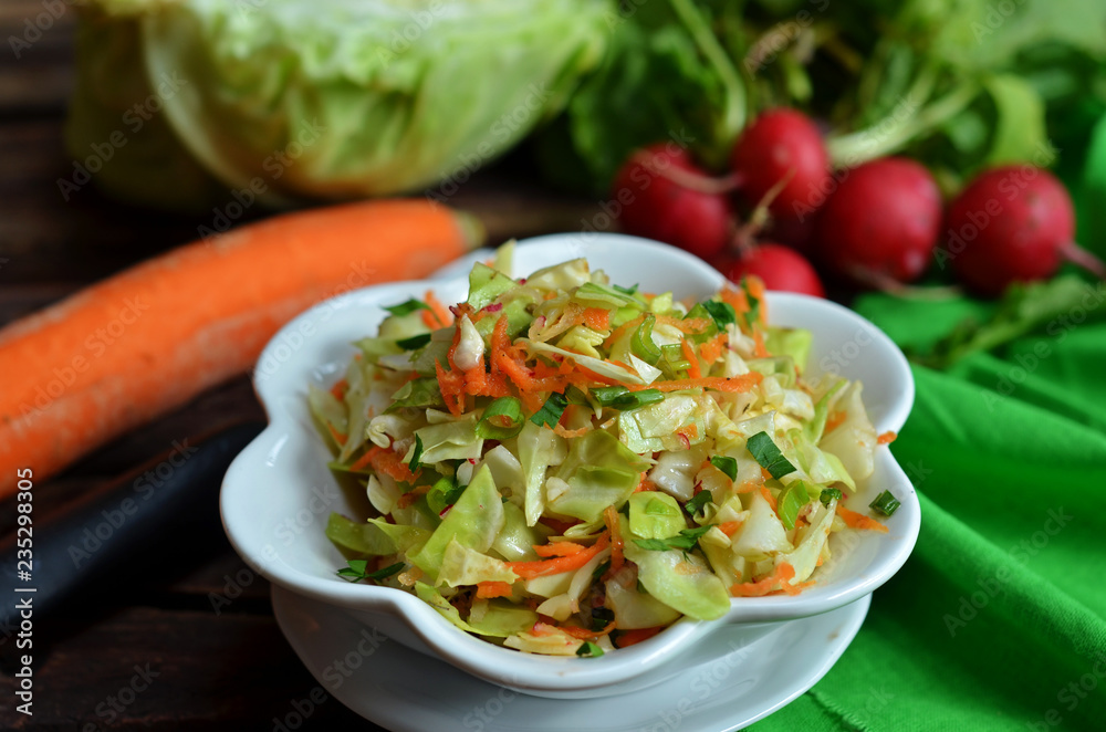 Young cabbage salad with carrot in a white bowl Young cabbage salad with carrot in a white bowl