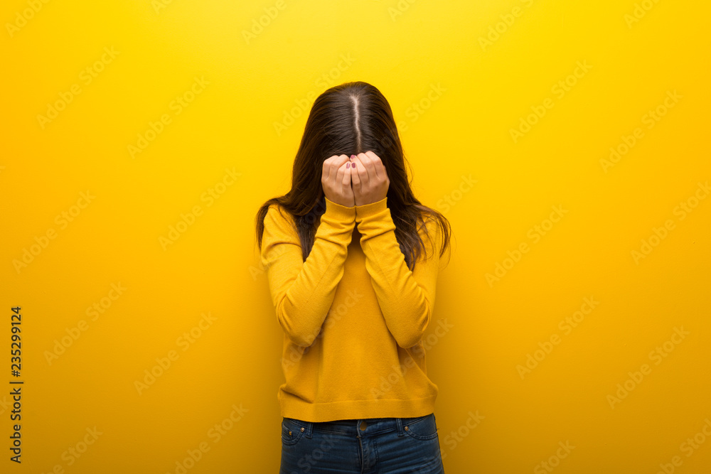 Teenager girl on vibrant yellow background with tired and sick expression Teenager girl on vibrant yellow background with tired and sick expression