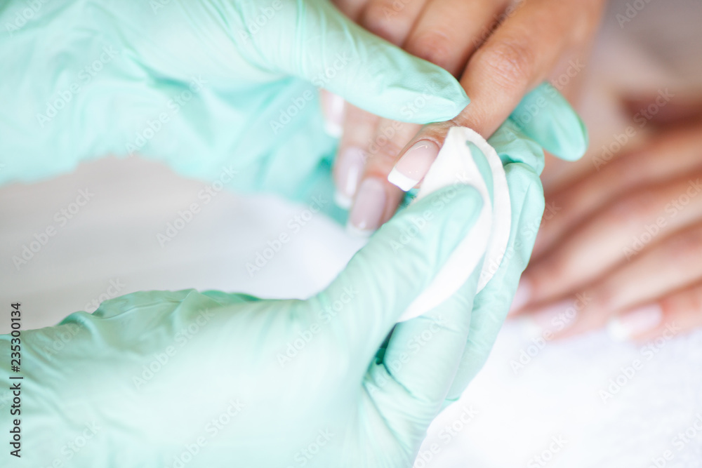 Fototapeta premium Woman Hand Care. Closeup Of Beautiful Female Hands Having Spa Manicure At Beauty Salon. Beautician Filing Clients Healthy Natural Nails With Nail File. Nail Treatment