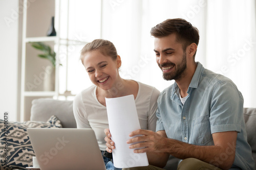 Obraz na plátne Happy husband and wife read good news online at laptop, millennial couple smilin