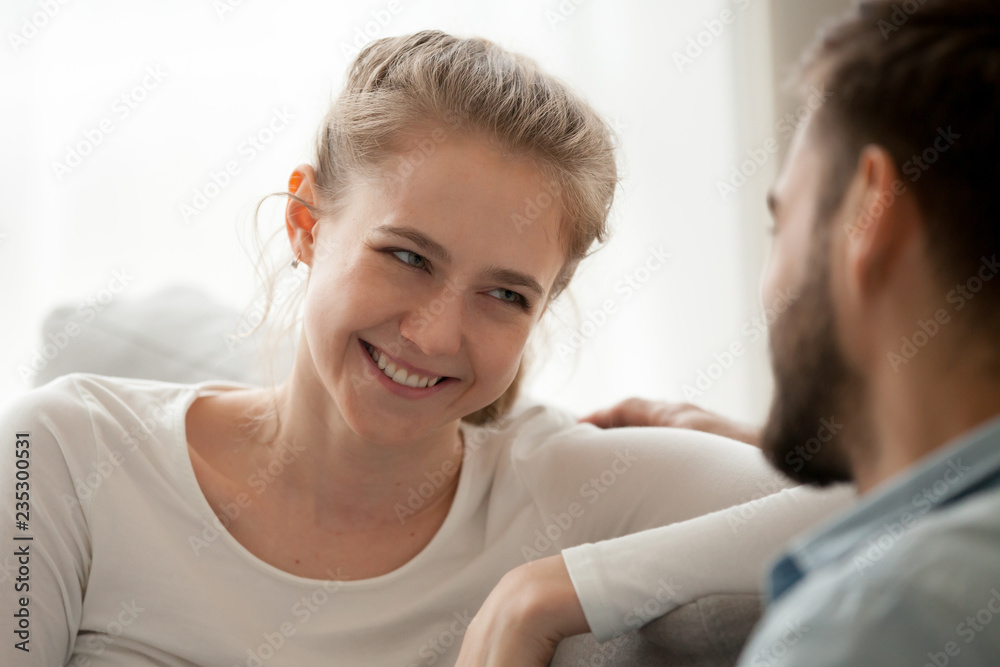 Close up of loving young woman look at beloved spouse relaxing on couch together, happy millennial wife admire husband cuddling on sofa at home, smiling female enjoy tender moment with spouse Close up of loving young woman look at beloved spouse relaxing on couch together, happy millennial wife admire husband cuddling on sofa at home, smiling female enjoy tender moment with spouse