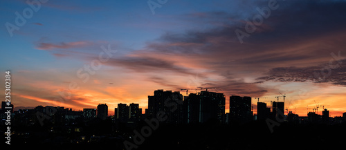 Colourful sunset sky over city with skyscrapers © Simon