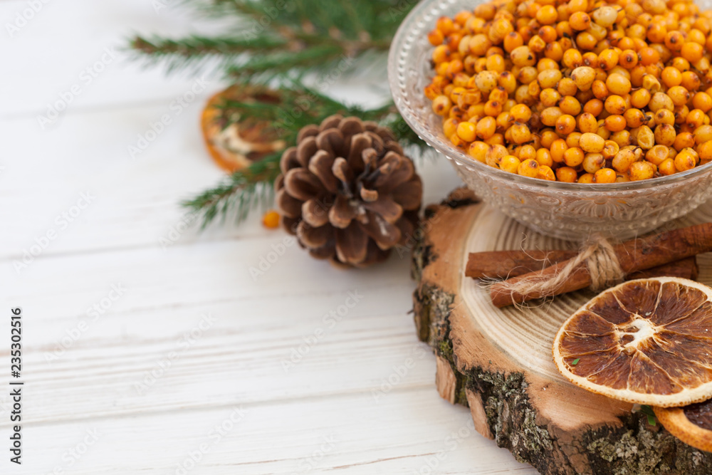Orange and sea buckthorn on a white wooden background, christmas food,  concept of seasonal vitamins and healthy eating. Copy space