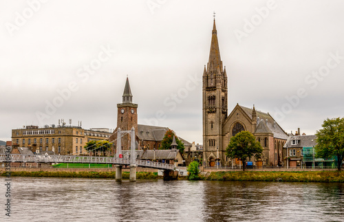 Bridge over river Ness leading to the famous tall gothic style Free Church of Scotland, Inverness