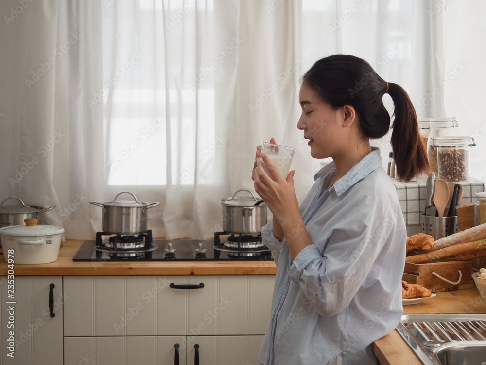 asian woman drink milk in the kitchen asian woman drink milk in the kitchen