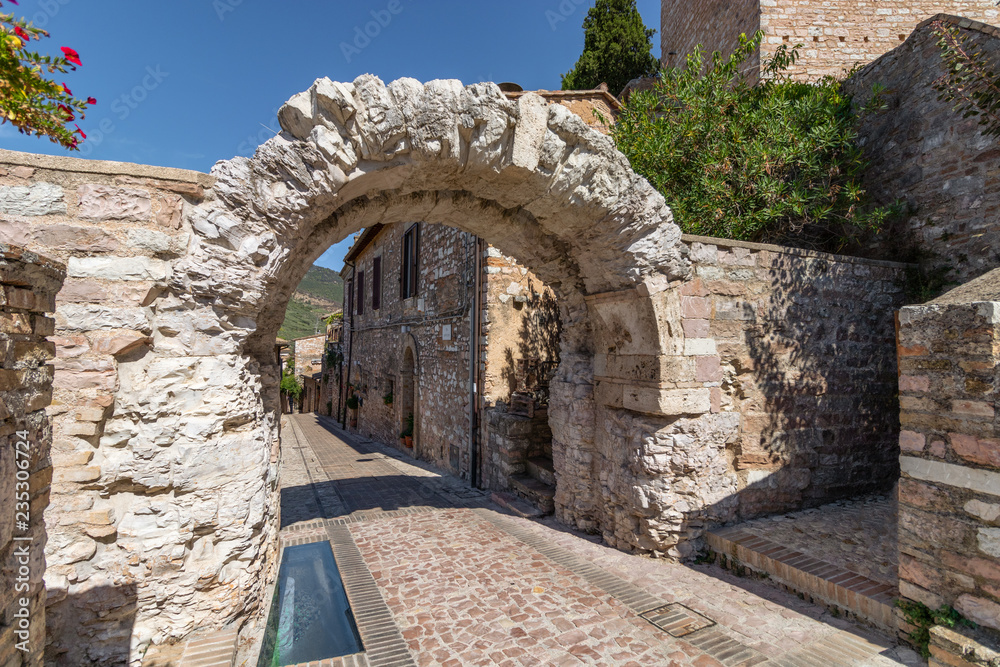 Famous roman arch (Porta dei Cappuccini) in Spello. Umbria, Italy