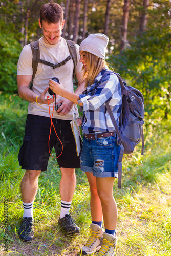 Young couple walking in the forest. Hiking concept in the mountain in summer