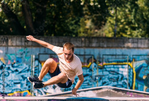 Sportive man running through obstacles in skatepark