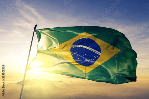 Brazil brazilian flag textile cloth fabric waving on the top sunrise mist fog photo