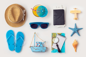 Travel holiday vacation concept with beach and travel items organized on white background