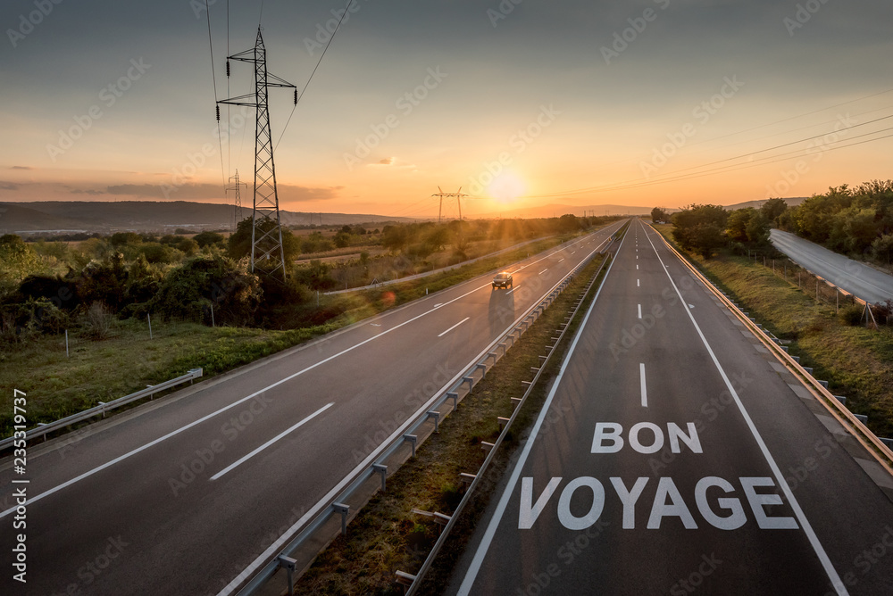Beautiful Countryside Motorway with a Single Car at sunset with motivational message Bon Voyage