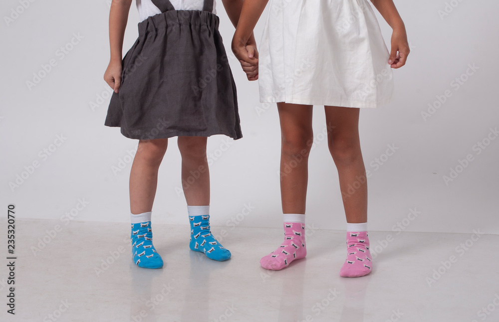 legs of two little girlfriends in knitted socks in a white studio legs of two little girlfriends in knitted socks in a white studio